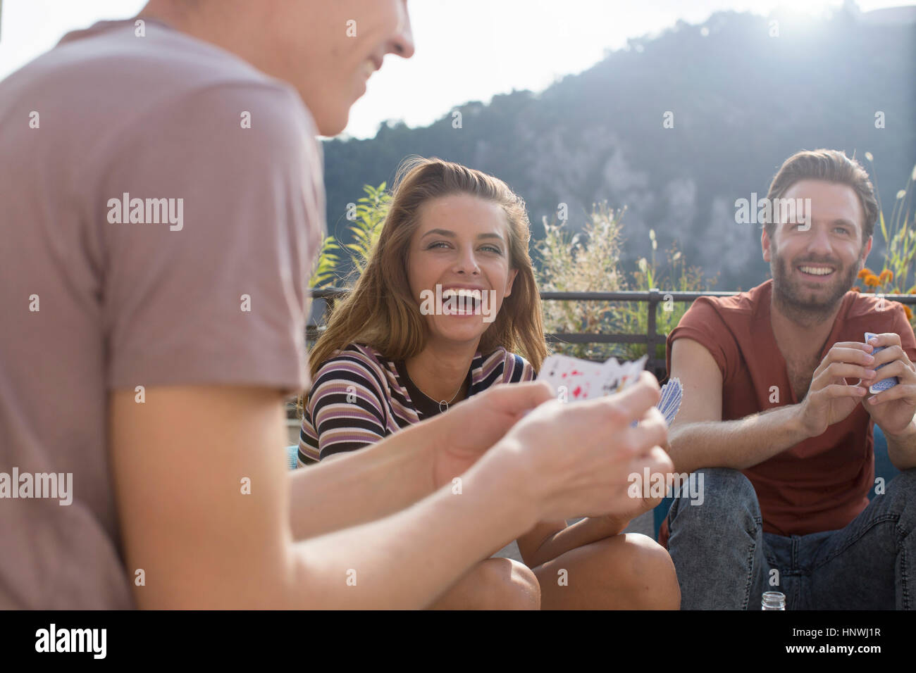 Adult friends having fun playing cards at roof terrace party Stock Photo