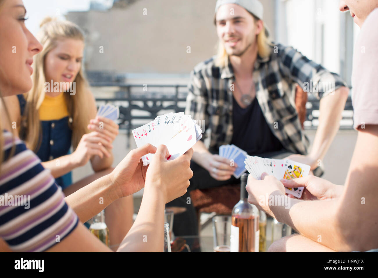 Young adults playing card game at roof terrace party, Budapest, Hungary Stock Photo