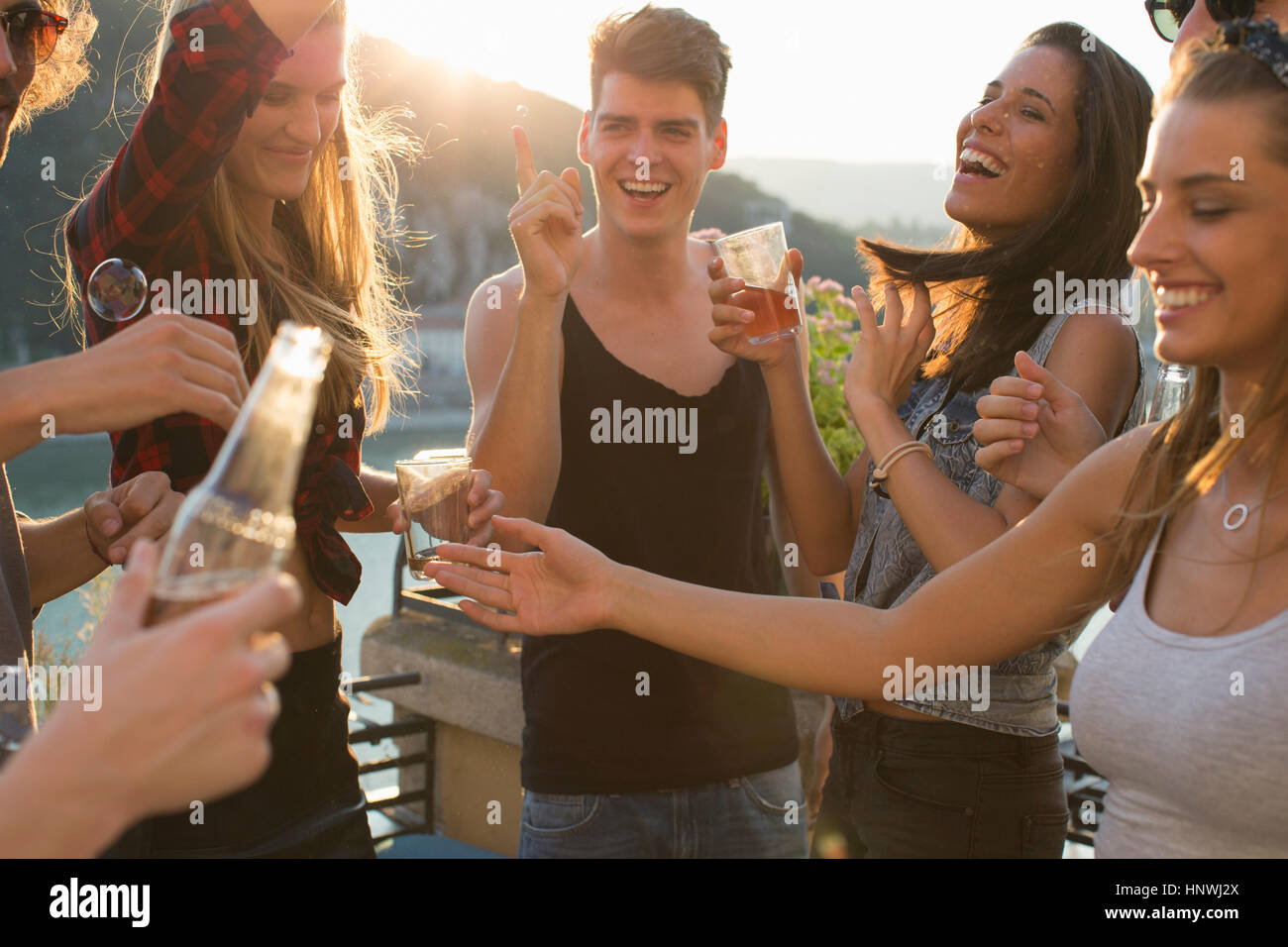 Adult friends partying on waterfront roof terrace, Budapest, Hungary Stock Photo