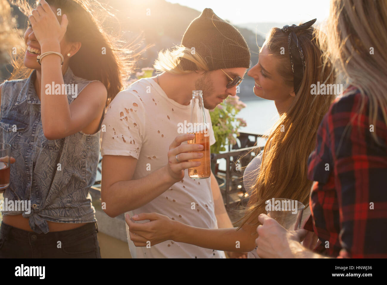 Adult friends dancing at waterfront roof terrace party, Budapest, Hungary Stock Photo