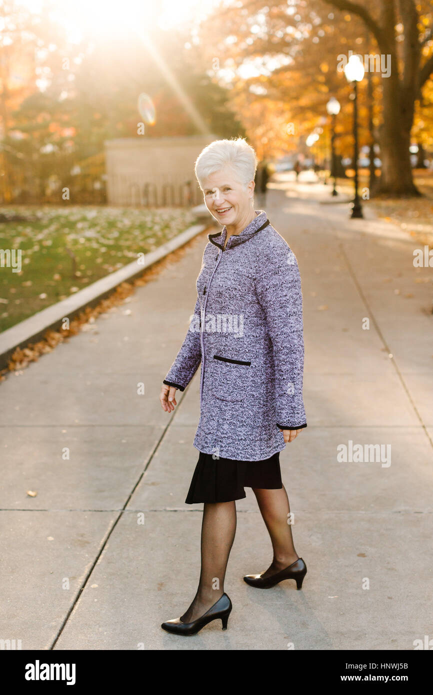 Portrait of senior woman, outdoors, wearing smart clothing Stock Photo