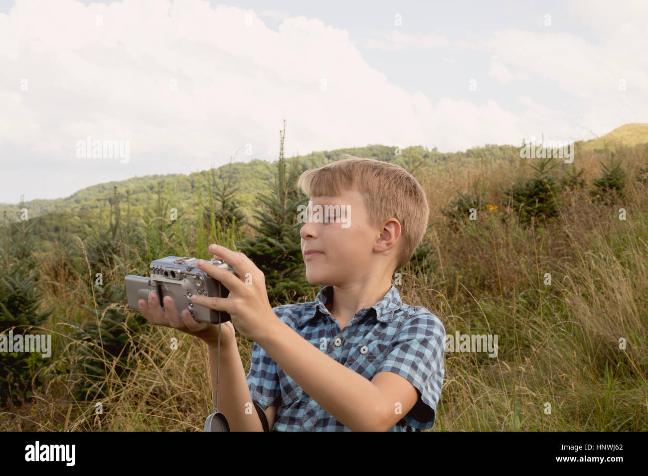 Young boy outdoors, looking at video camera Stock Photo - Alamy