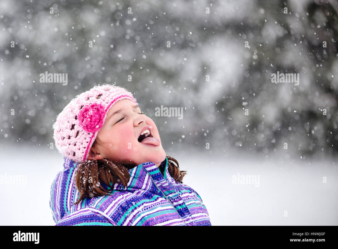 Girl catching snowflake on her tongue Stock Photo