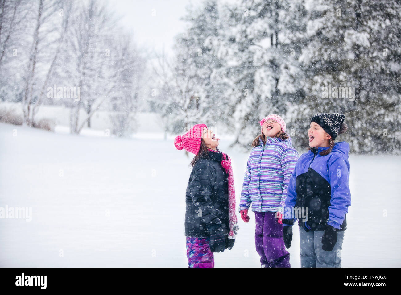 Friends catching snowflake on their tongues Stock Photo