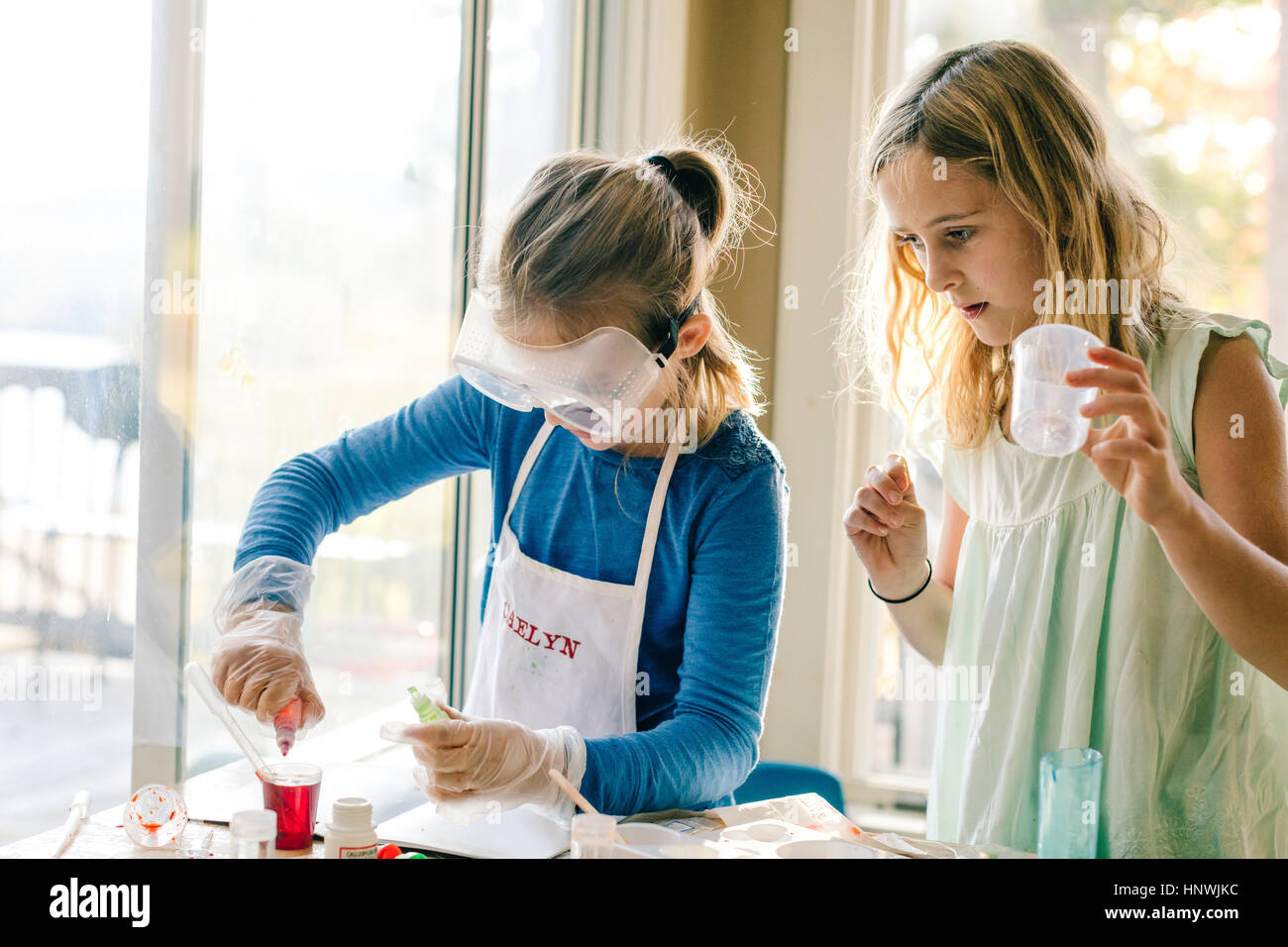 Two girls doing science experiment, with red liquid Stock Photo Alamy
