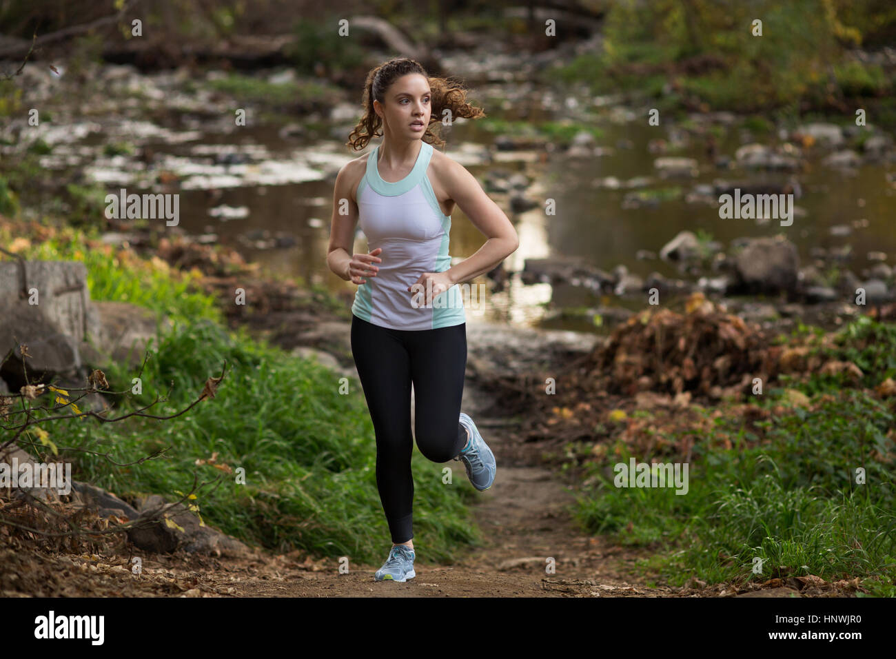 Young woman exercising, running, near river Stock Photo