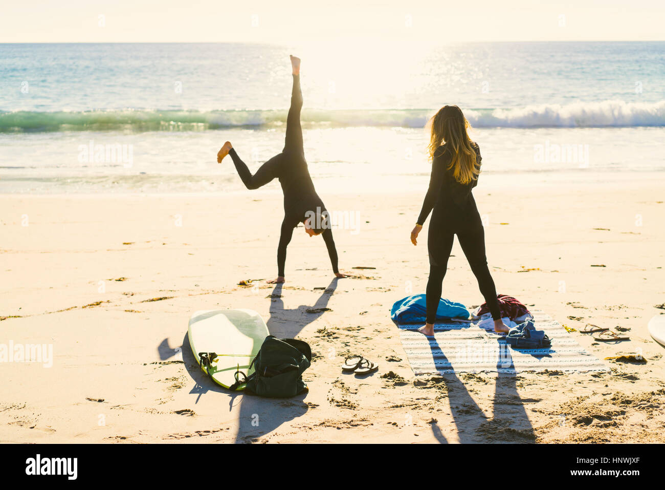 Surfing couple cartwheeling on Newport Beach, California, USA Stock Photo