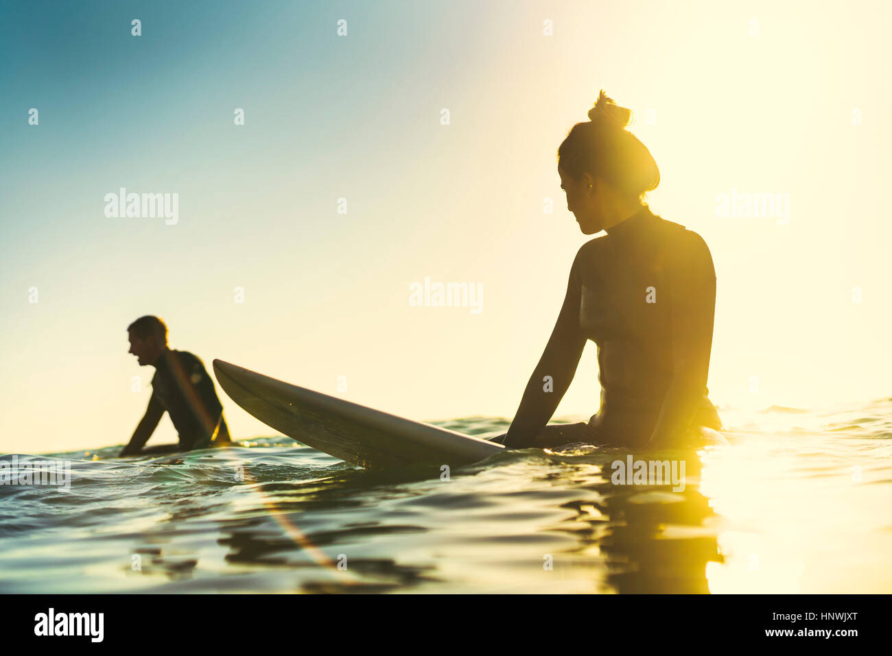 Surfing couple wading in sea, Newport Beach, California, USA Stock Photo