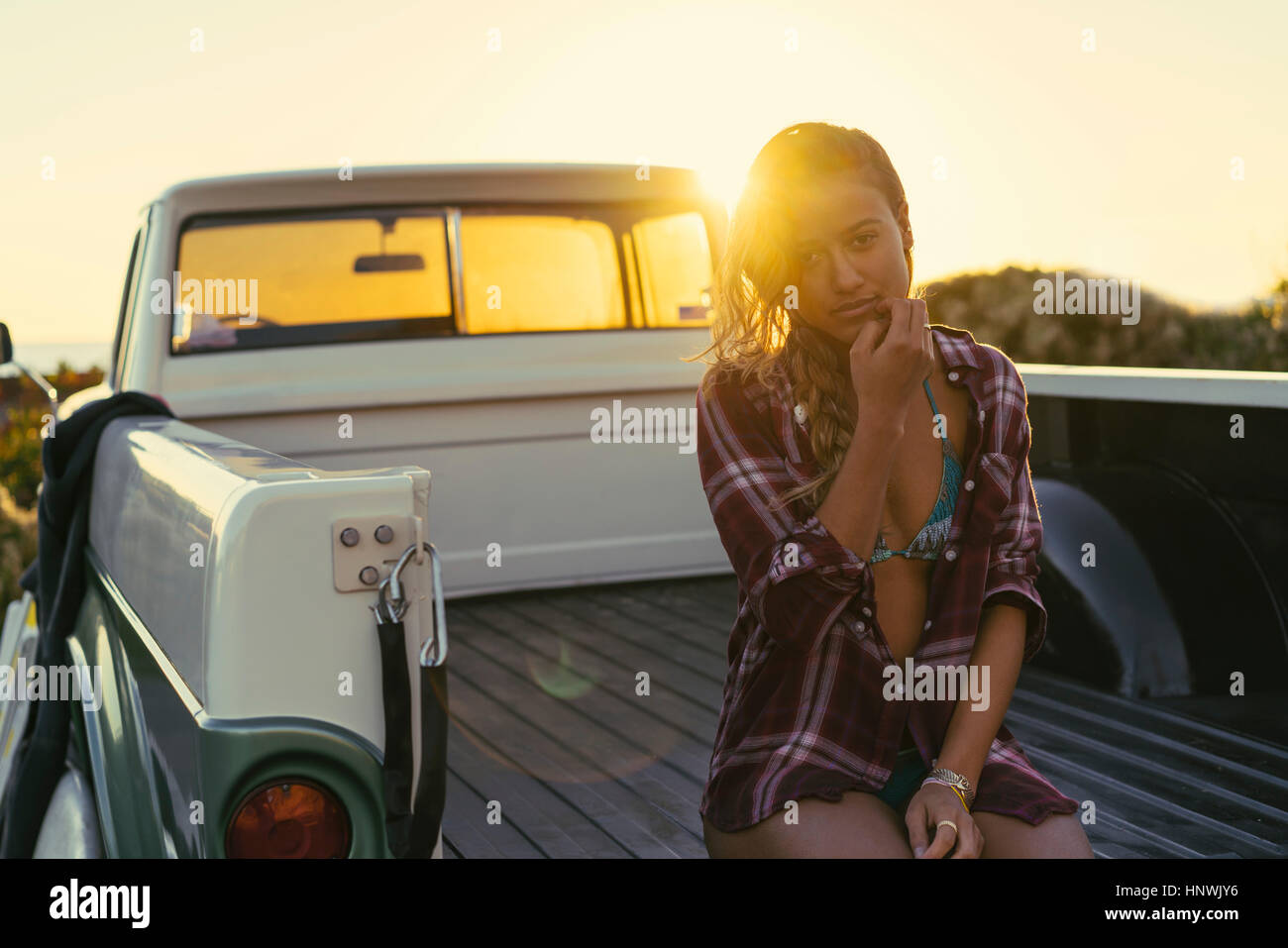 Portrait of young female surfer in back of pickup truck at Newport Beach, California, USA Stock Photo