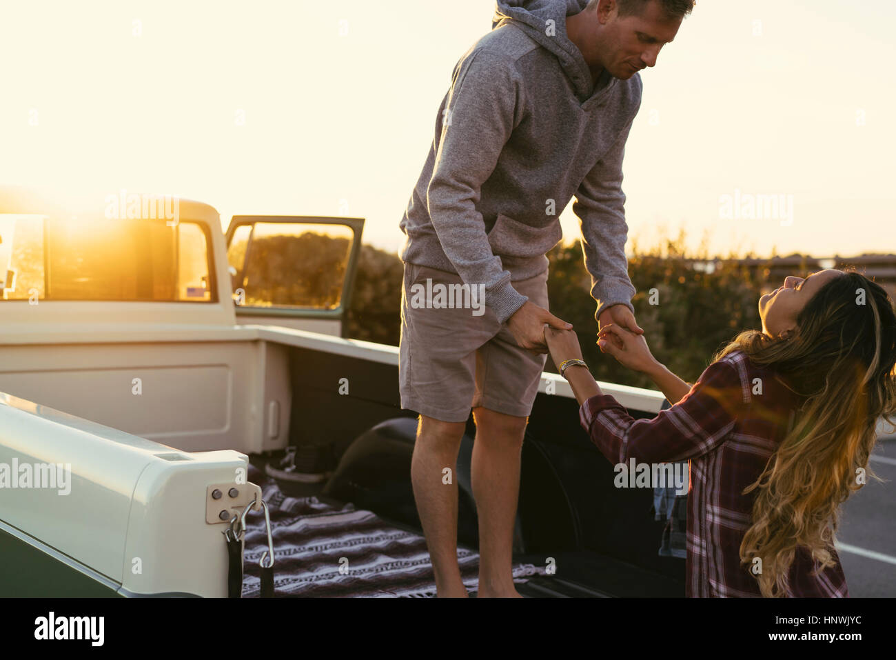 Couple holding hands at back of pickup truck at Newport Beach, California, USA Stock Photo