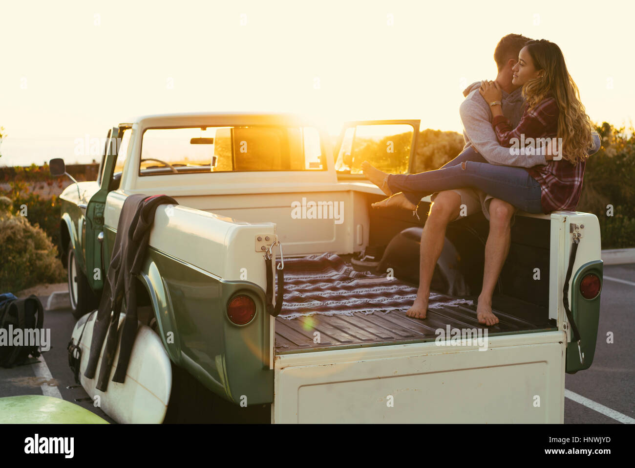 Surfing couple in back of pickup truck at Newport Beach, California, USA Stock Photo