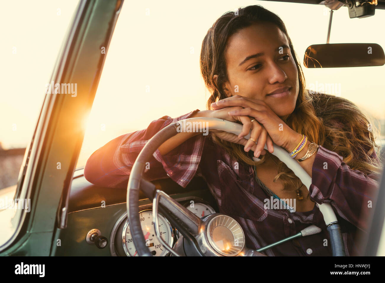 Young woman leaning against steering wheel in pickup truck at Newport Beach, California, USA Stock Photo
