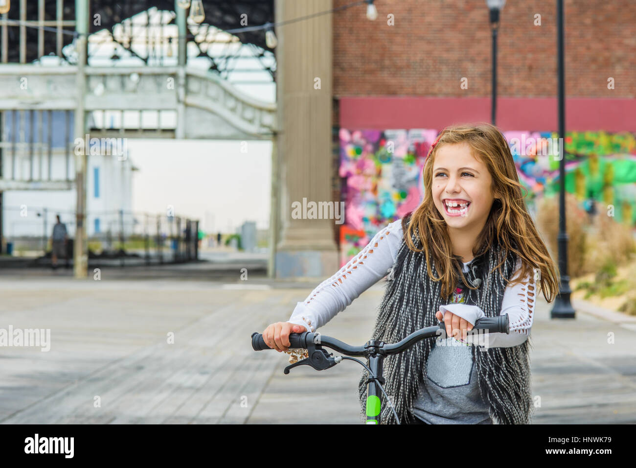 Girl with push scooter in urban setting Stock Photo