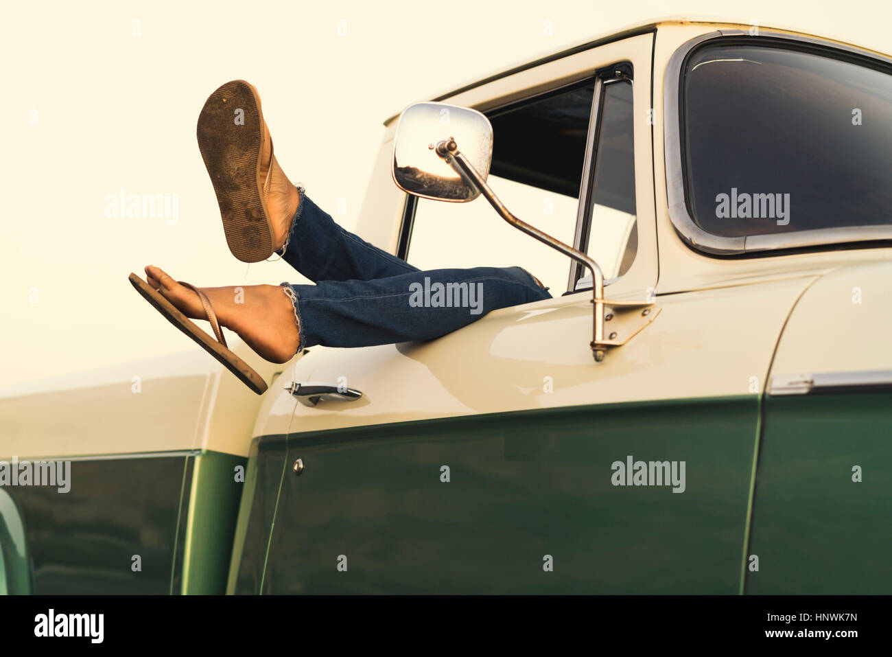 Legs of young woman out of pickup truck window at Newport Beach, California, USA Stock Photo