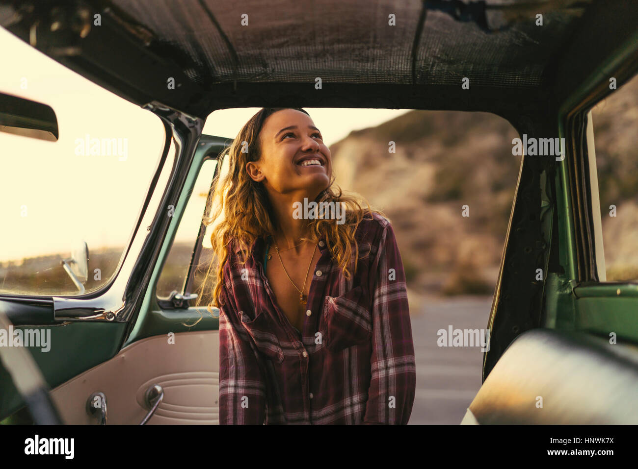 Happy young woman at pickup truck door at Newport Beach, California, USA Stock Photo