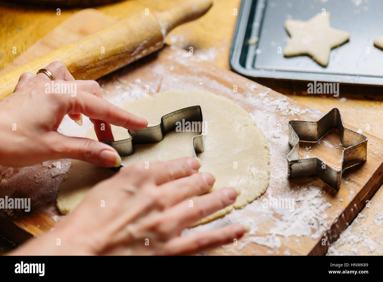 Mature woman pressing cookie cutter into dough, close-up Stock Photo