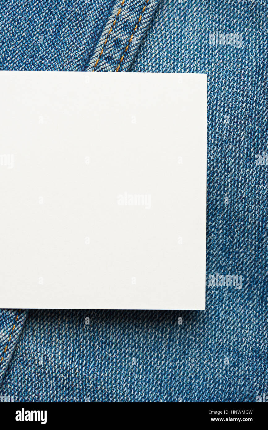 White empty tag on blue jeans background close up Stock Photo