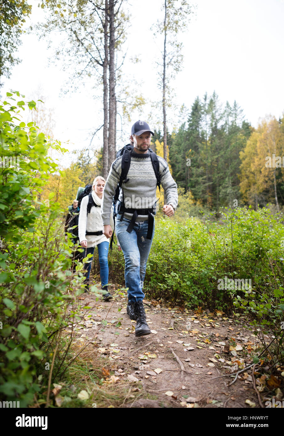 Man With Friends Walking On Hiking Trail Stock Photo