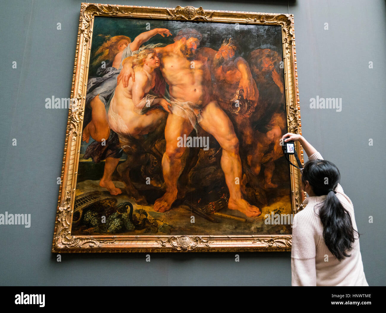 Woman photographing painting 'The Drunken Hercules being Led by a Nymph' by Peter Paul Rubens at GemŠldegalerie Alte Meister or Zwinger Museum in Dres Stock Photo