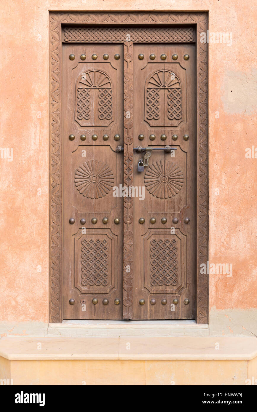 Old carved door. Wooden entrance door to an old Arabic fort in Al Ain