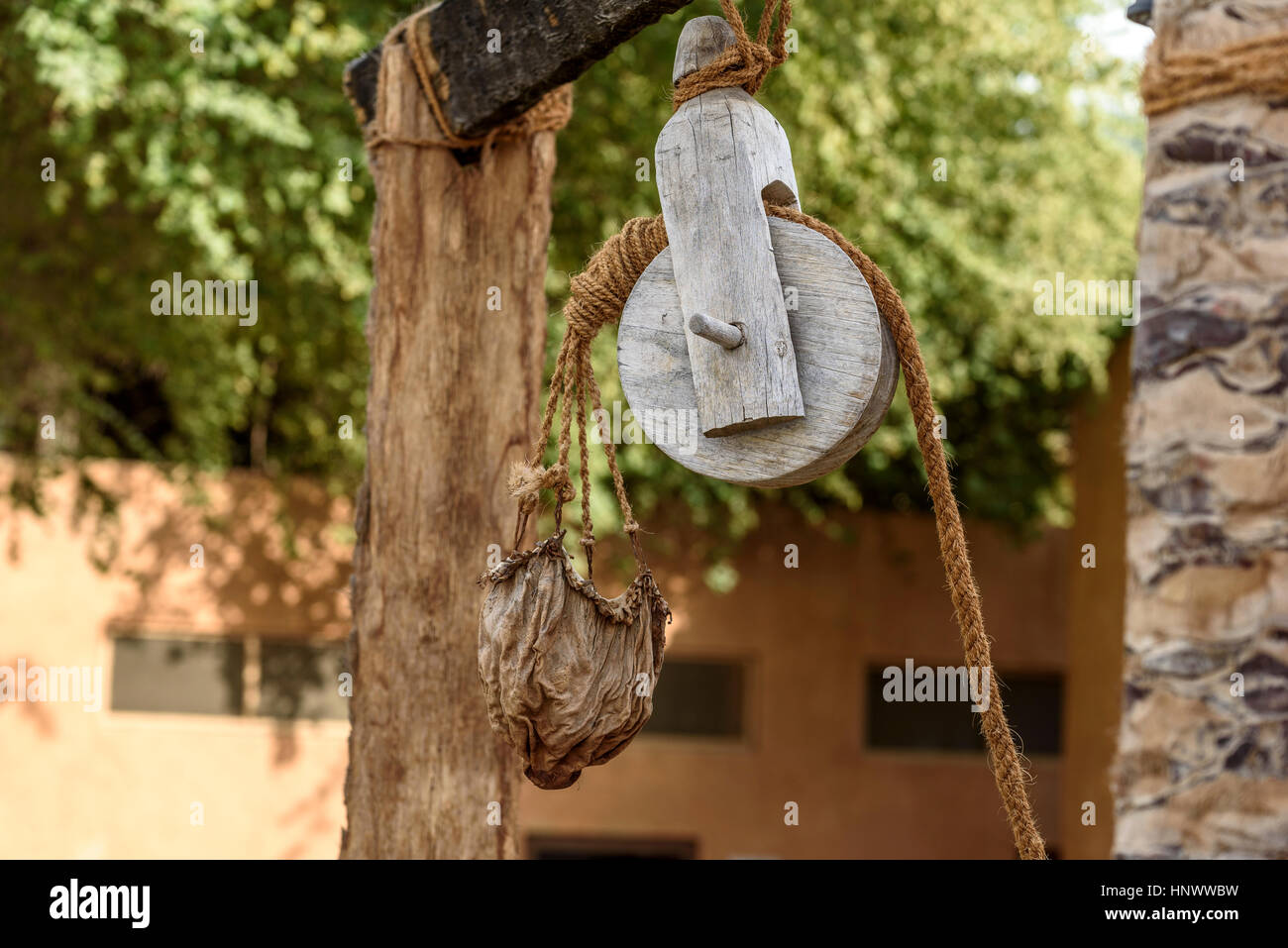 Old pulley and leather water bucket. Wooden pulley with natural fibre