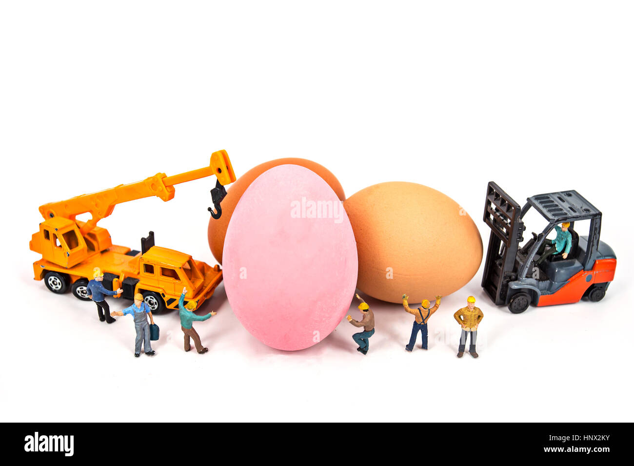 selective focus of miniature worker people and pink egg , abstract background for easter holiday concept. Stock Photo