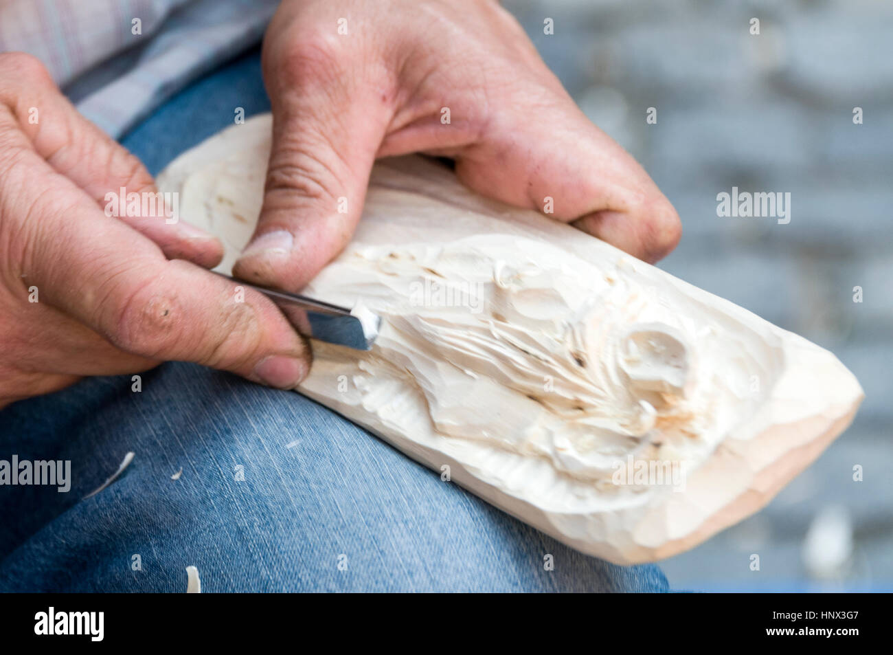A woodcarver, carving a piece of wood as a tourists souvenir at the