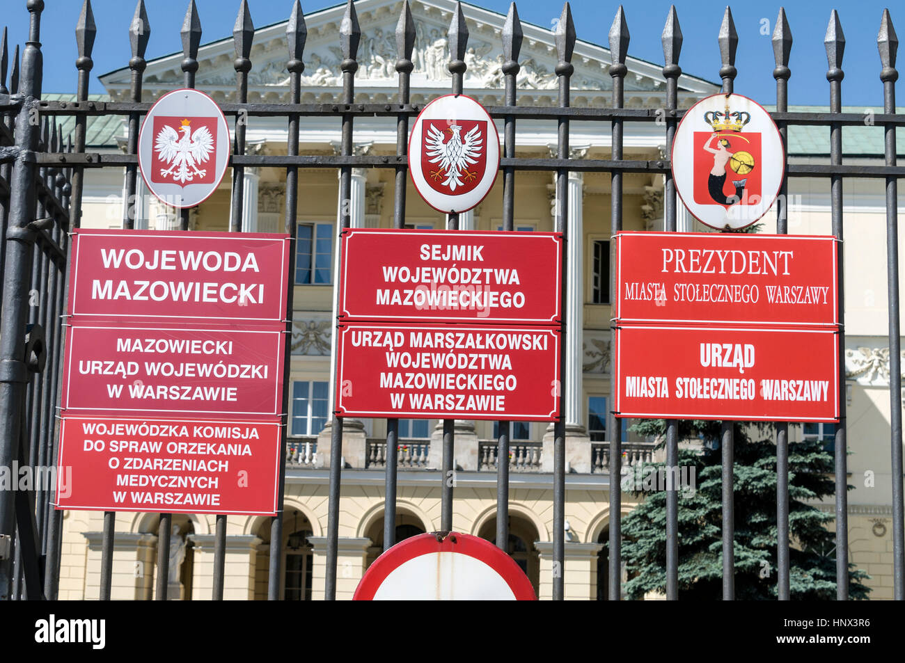 On the railings of  Warsaw City Hall, Poland  is the Coat of Arms of Poland, Coat of Arms of Mazovia region and seat of Mazovia Voivodeship ,and the c Stock Photo