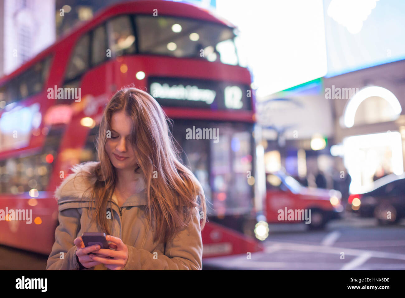 Young woman using mobile phone in street, London, UK Stock Photo