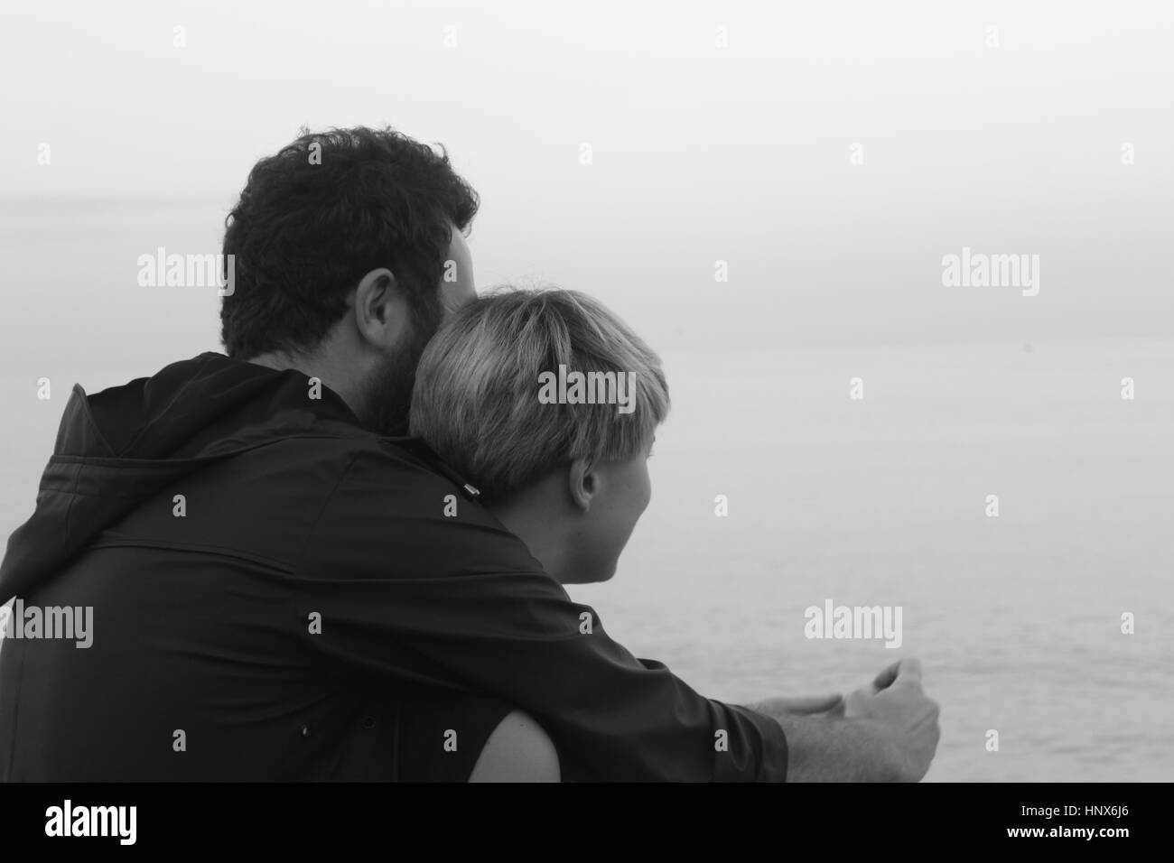 Young couple looking out to sea, rear view Stock Photo
