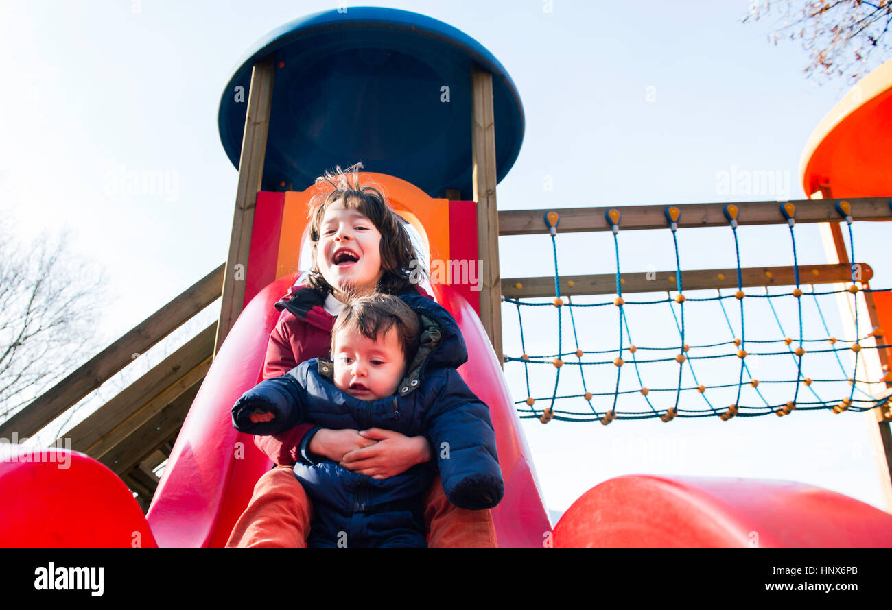boy-and-baby-brother-sliding-down-playground-slide-stock-photo-alamy