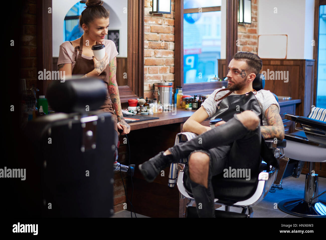Hairdressers taking a break in barbershop Stock Photo