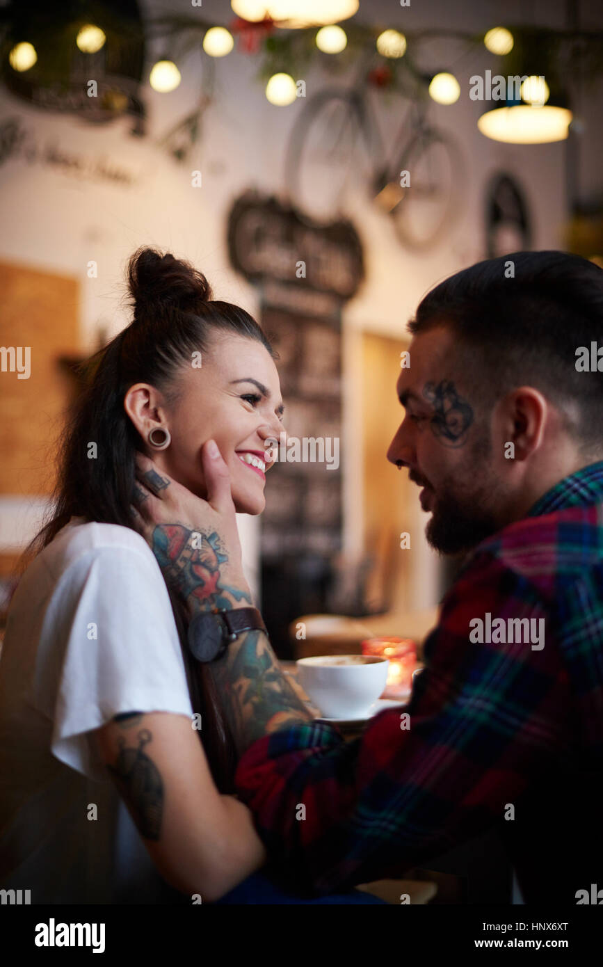 Couple in coffee shop face to face smiling Stock Photo