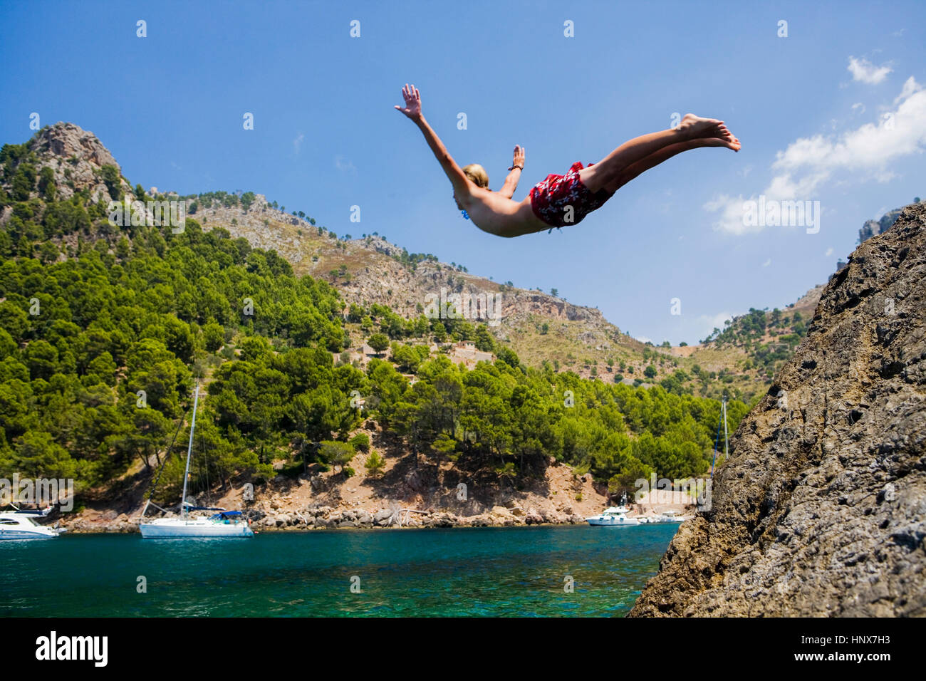 Young man diving into sea, Cala Tuent, Majorca, Spain Stock Photo