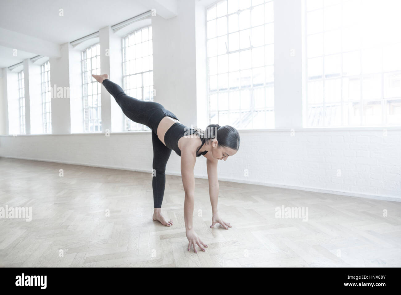 Woman in dance studio bending forwards stretching Stock Photo