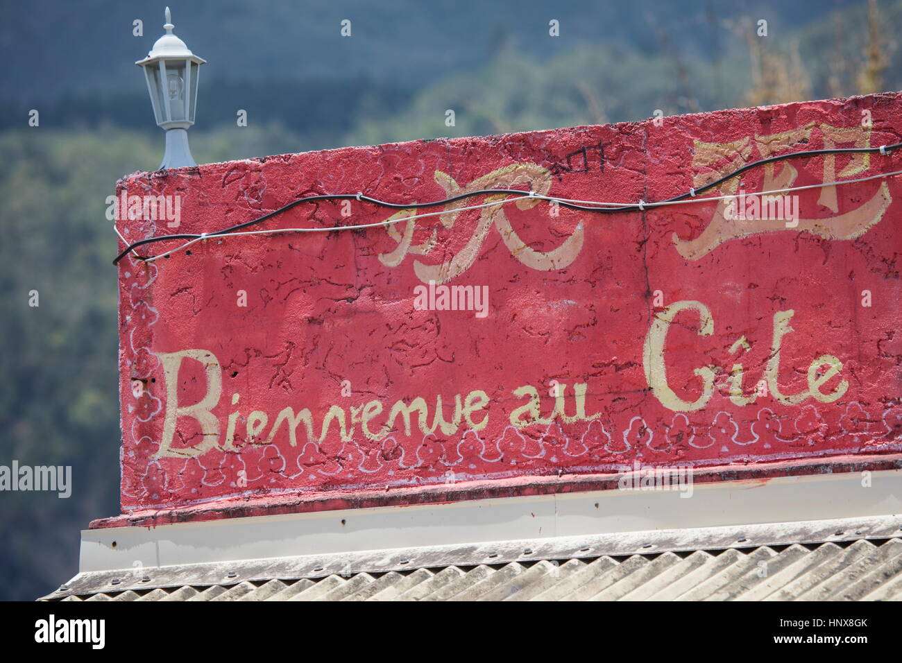 Red french language sign on bed and breakfast roof terrace wall, Reunion Island Stock Photo