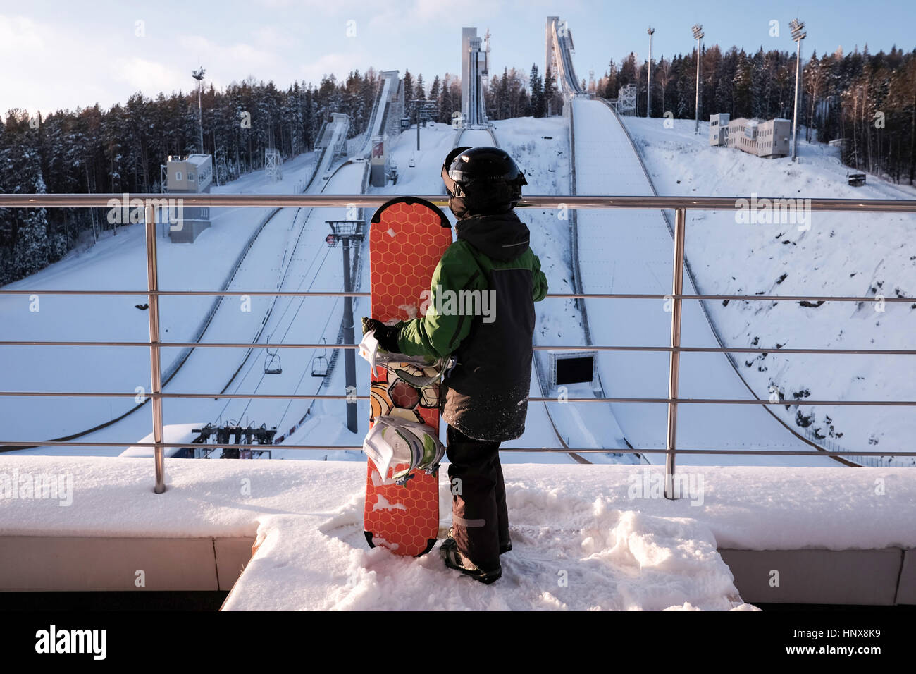 Rear view of boy with snowboard at top of ski slope Stock Photo - Alamy