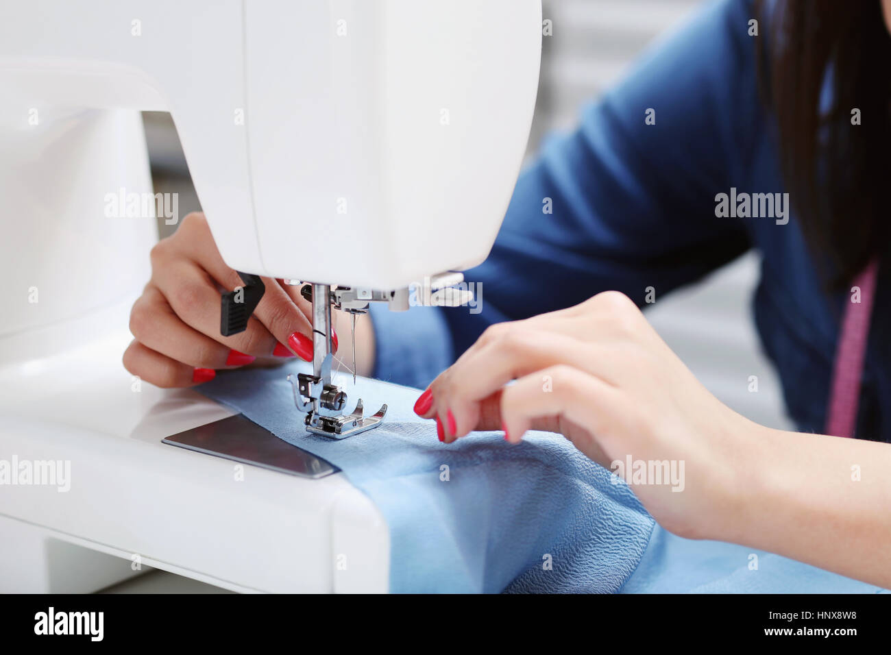 Lovely seamstress at the table Stock Photo