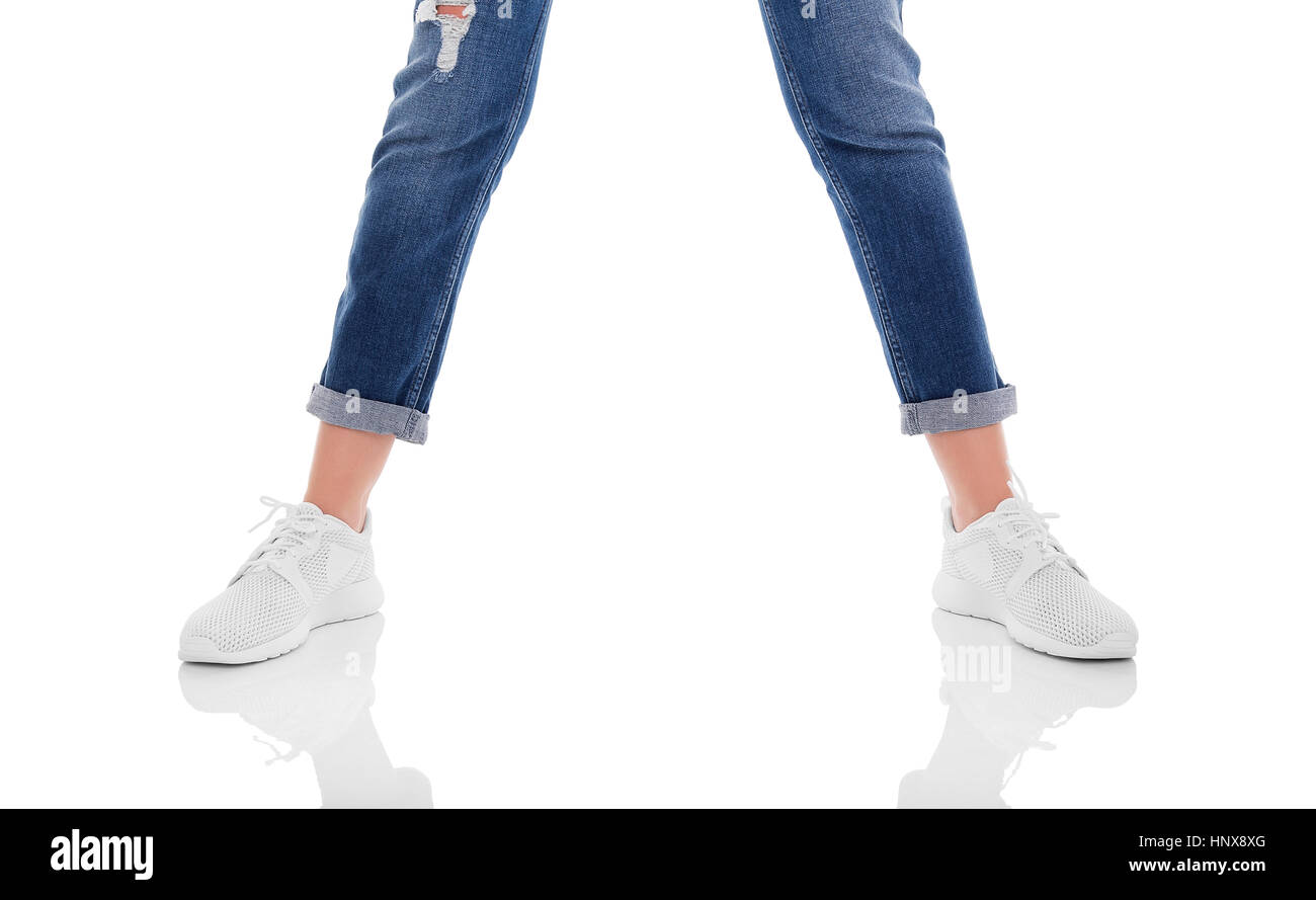 Women's legs in jeans and sneakers. Isolated on white background Stock ...