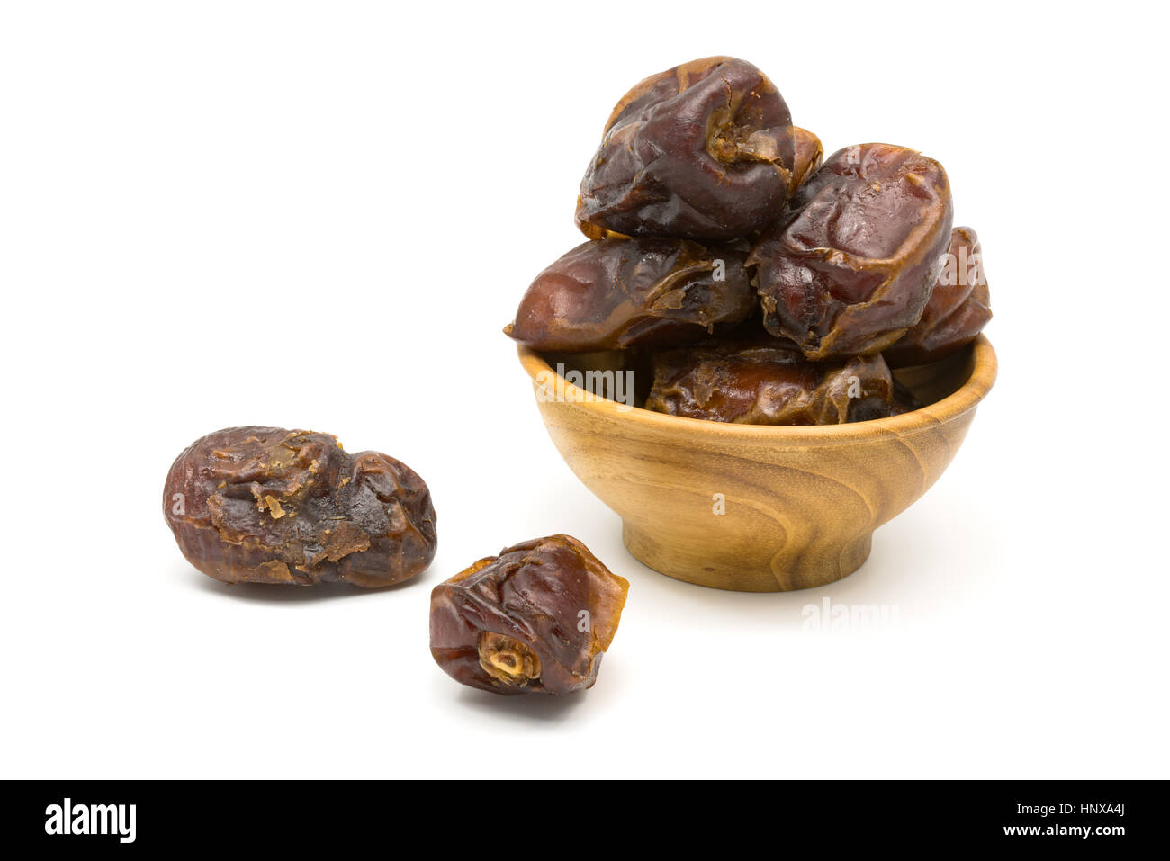 Dates fruit in a wooden bowl on white background Stock Photo - Alamy