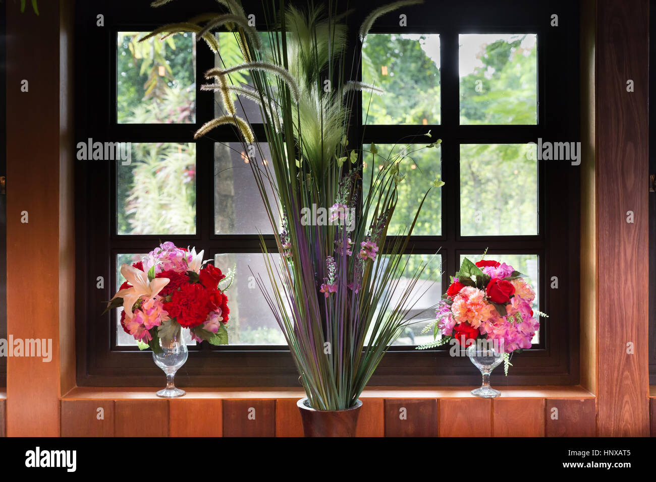 artificial flower bouquet decorating beside window Stock Photo - Alamy