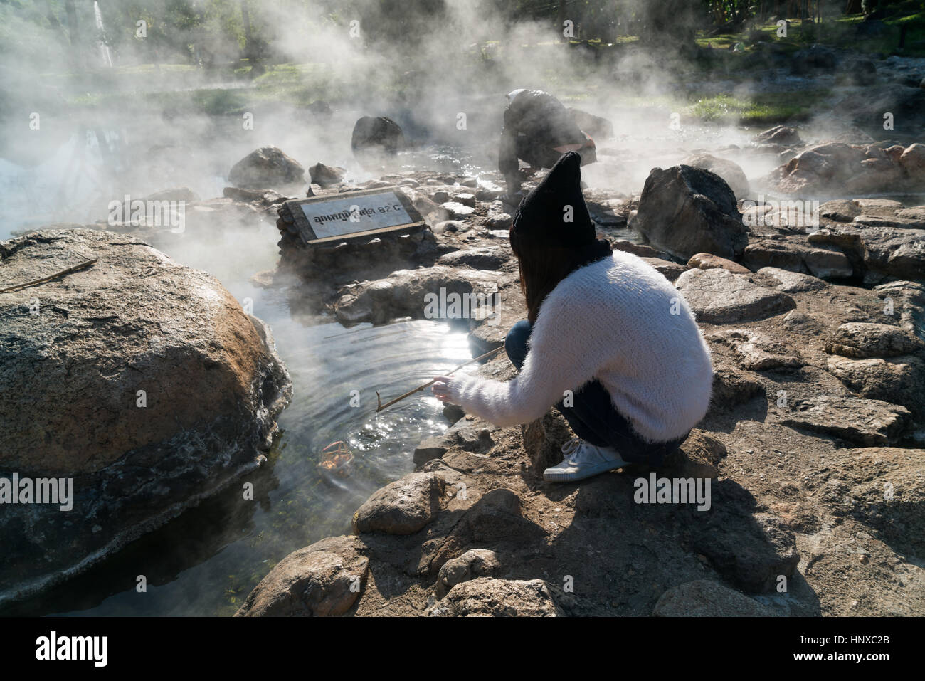 Teen girl boiling eggs in hot water in front of a board showing the