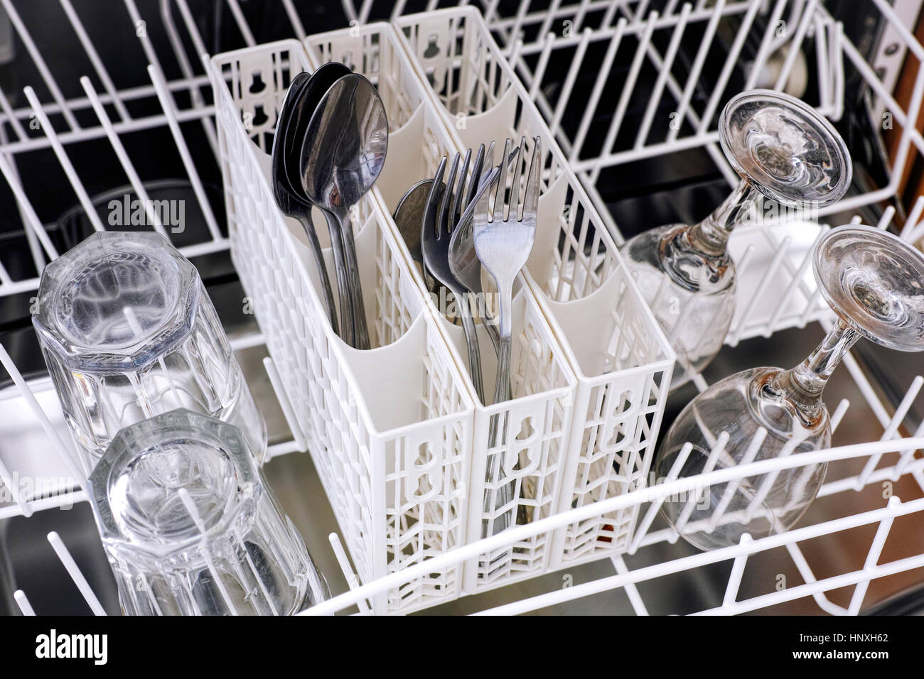 Open dishwasher with spoons, forks, glasses and wine glasses ready to be clean Stock Photo Alamy