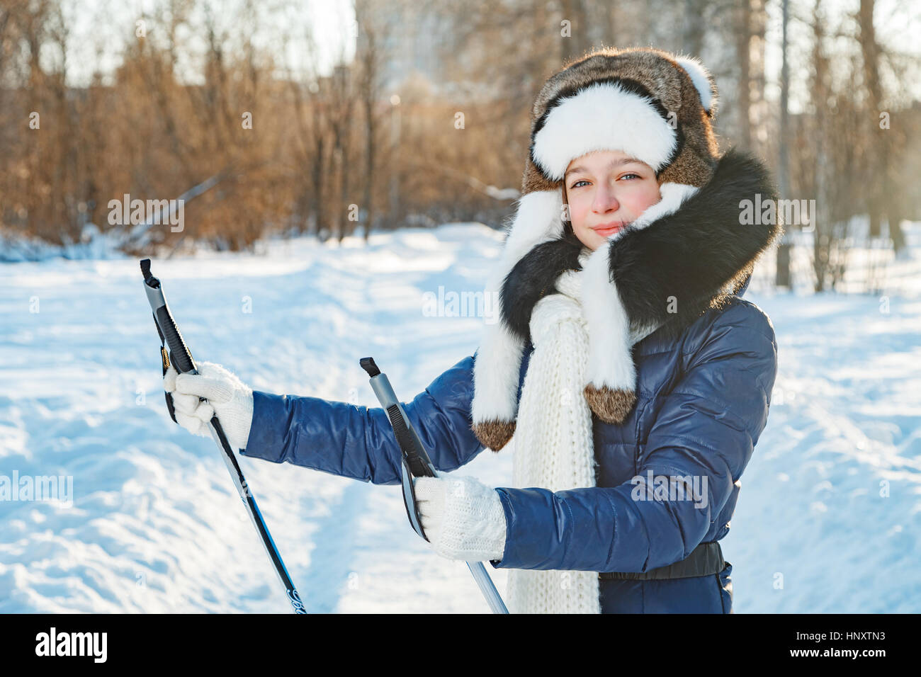 Cross-country skiing woman doing classic nordic cross country skiing in trail tracks in snow covered forest Stock Photo