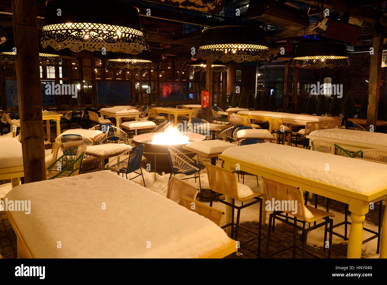 Snow Covered Tables And Chairs With Fire Pit In Empty Outdoor
