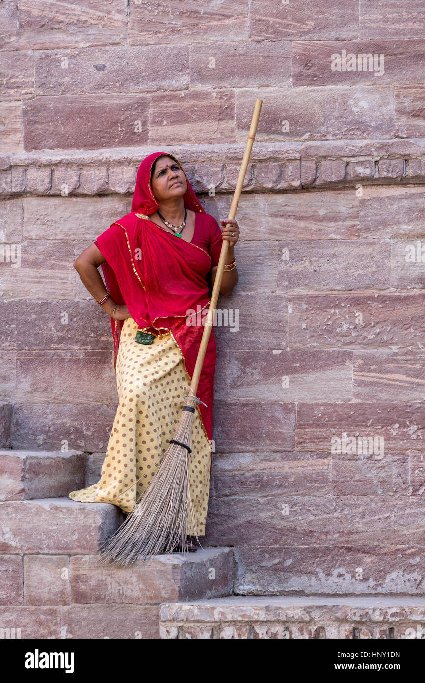 Indian woman in red Sari cleaning the steps at Toorji Ka Jhalara, The ...
