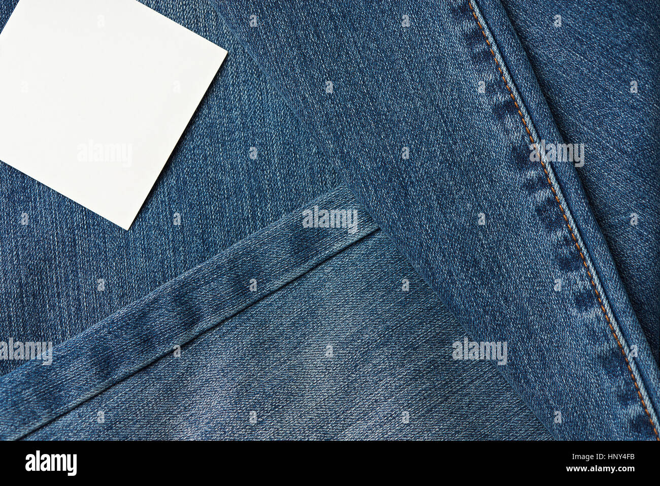 jeans fabric background with texture and stitches, white label tag Stock Photo