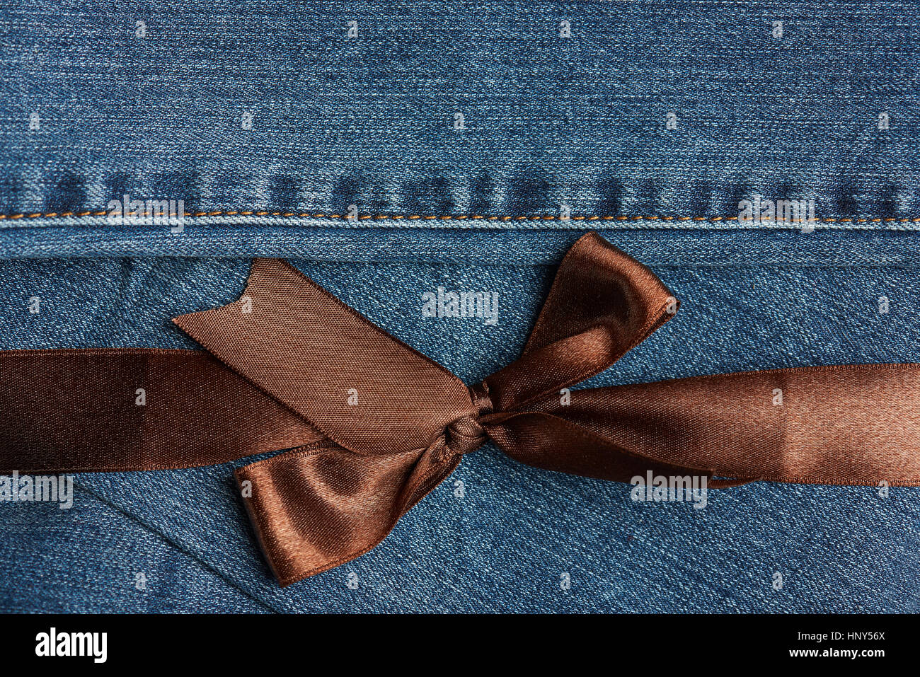 Brown ribbon on blue jeans texture horizontal close up Stock Photo