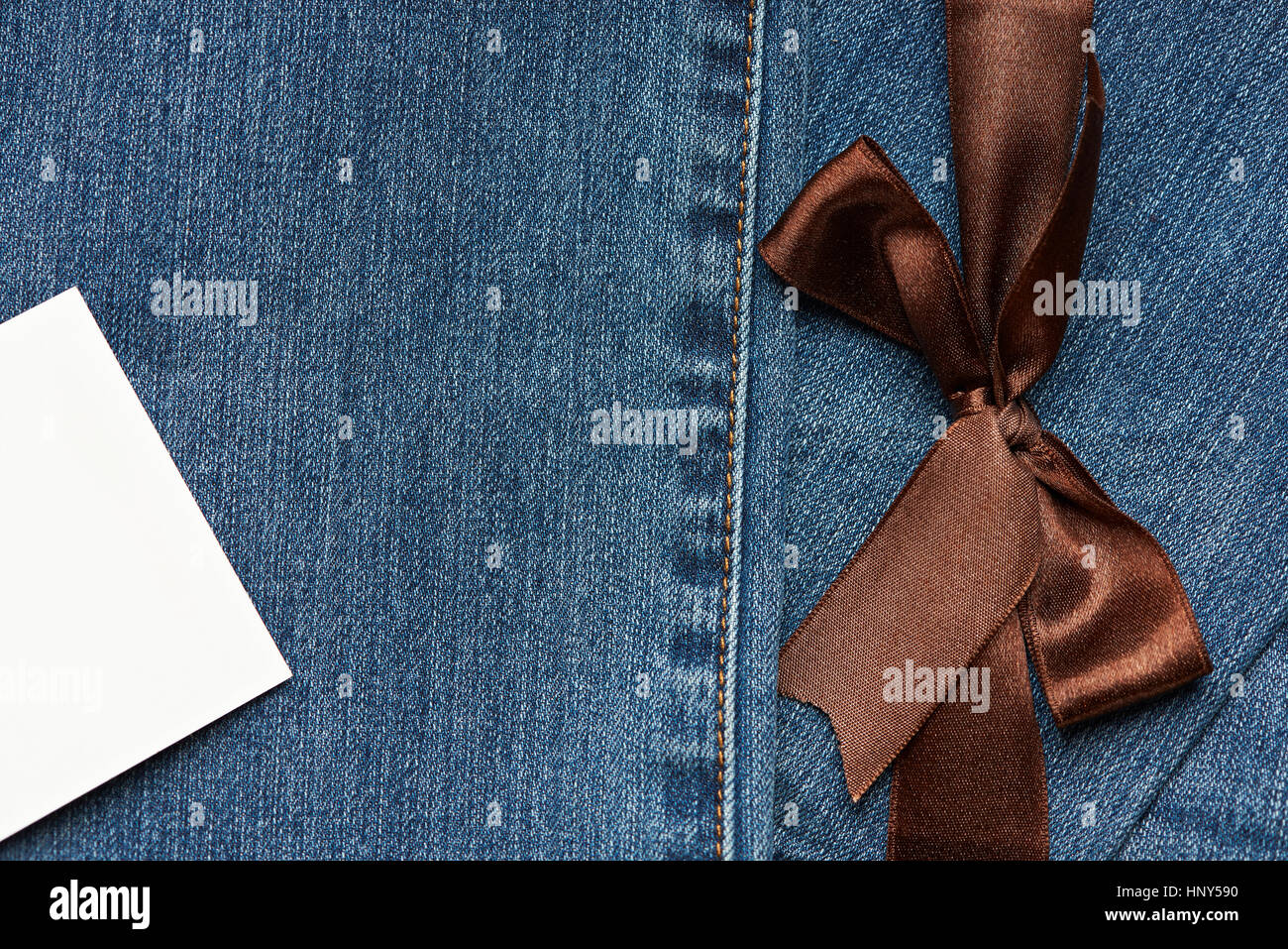 Blue Jeans texture with brown ribbon and white empty tag label Stock Photo