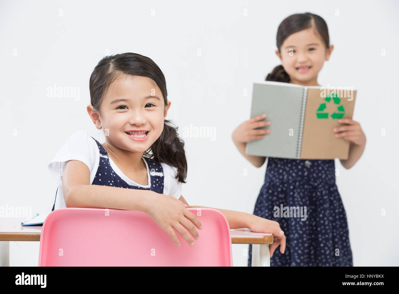 Smiling twin girls with books Stock Photo